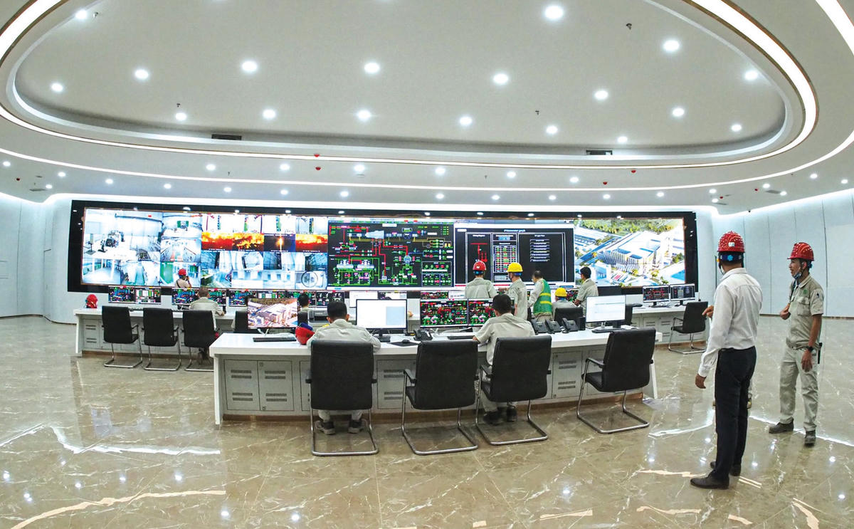 Các kỹ thuật viên đang theo dõi, vận hành hệ thống máy móc.  