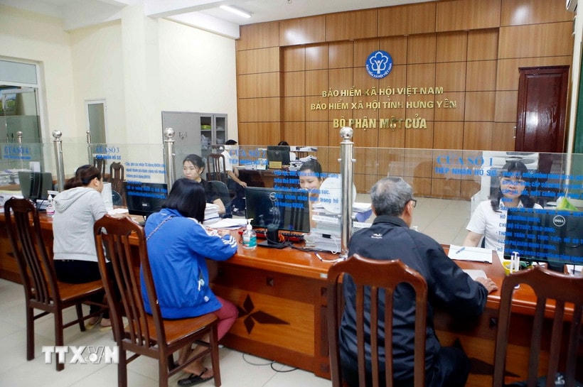 Nhân viên Bảo hiểm Xã hội tỉnh Hưng Yên hướng dẫn người dân làm thủ tục tham gia Bảo hiểm xã hội. (Ảnh: Phạm Kiên/TTXVN)