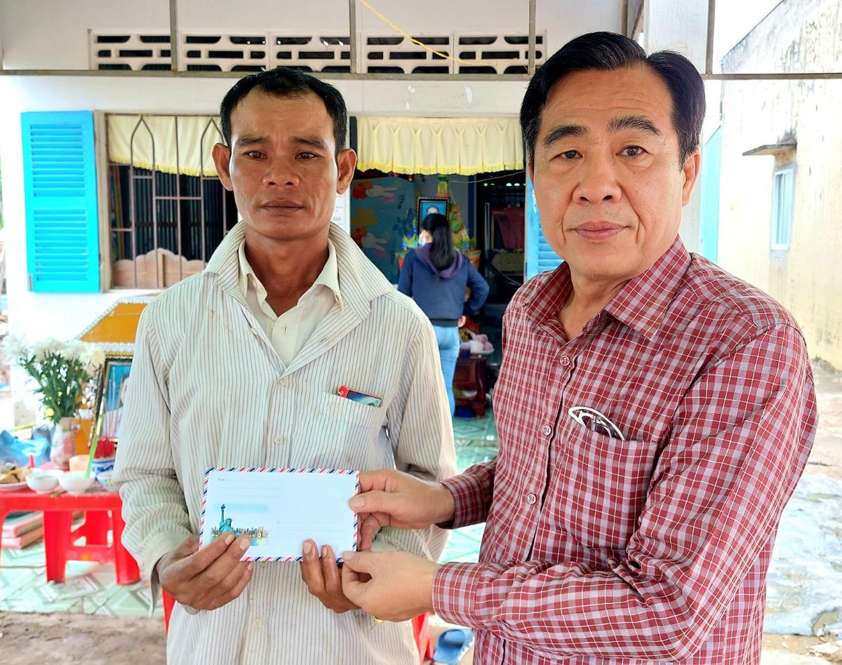 Ông Trần Văn Út trao tiền hỗ trợ cho gia đình nạn nhân.