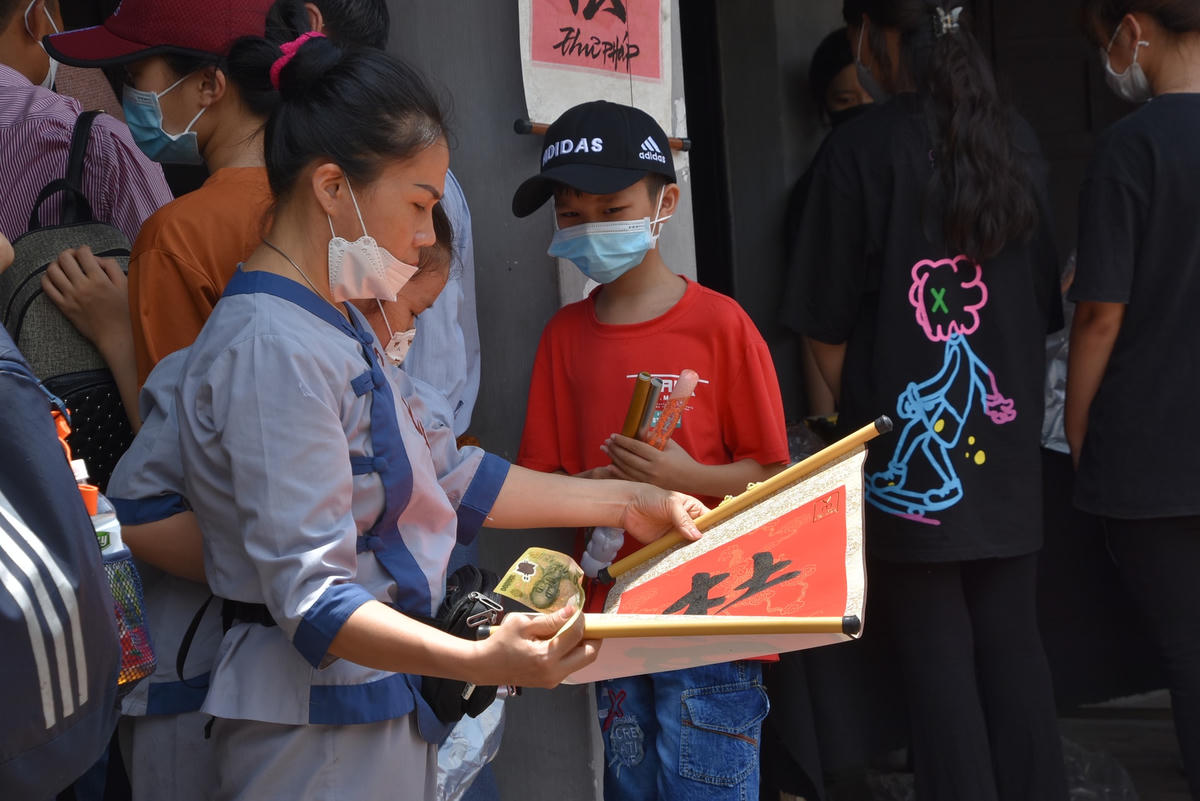 Nhiều phụ huynh tranh thủ trời nắng để hong chữ cho nhanh khô mực. 