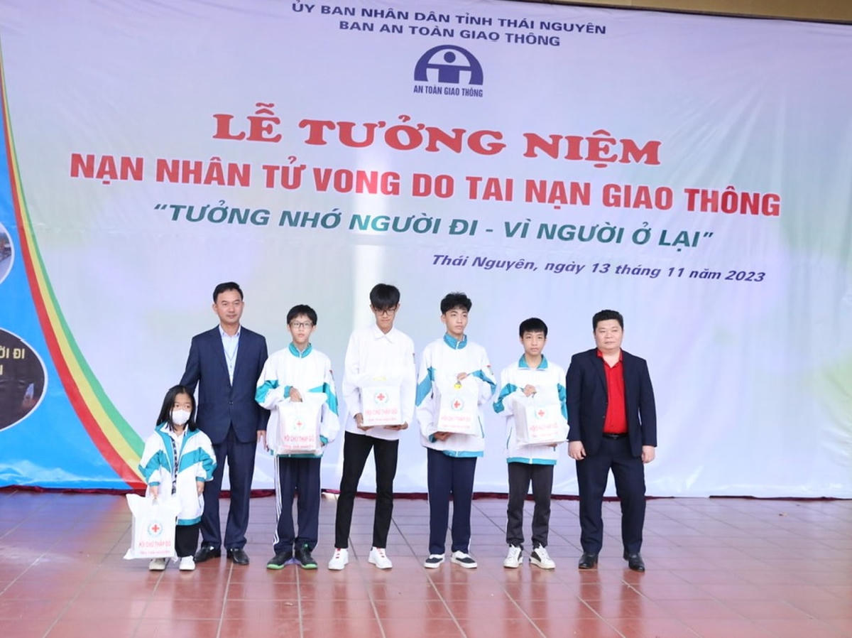 Đại diện Ban An toàn giao thông tỉnh và Hội Chữ thập đỏ tỉnh tặng quà cho những học sinh có thân nhân bị TNGT. Ảnh: Sở GTVT Thái Nguyên.