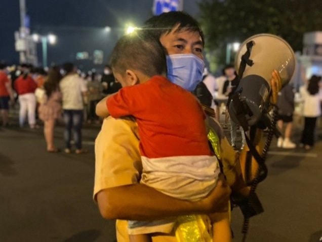 Đồng chí Thiếu tá Đinh Minh Vương đang phát loa tìm cha mẹ bé trai.