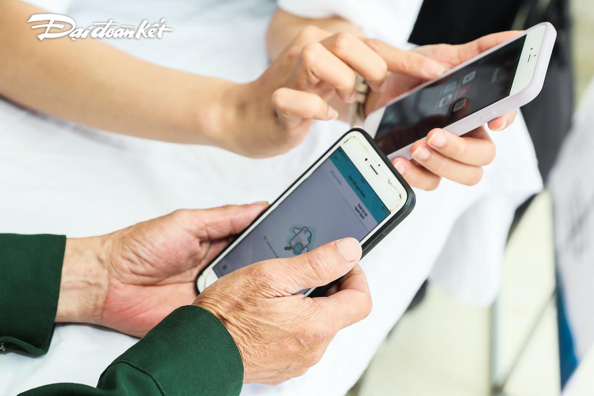Người dân được hướng dẫn cài đặt phần mềm theo dõi sức khoẻ trên điện thoại.
