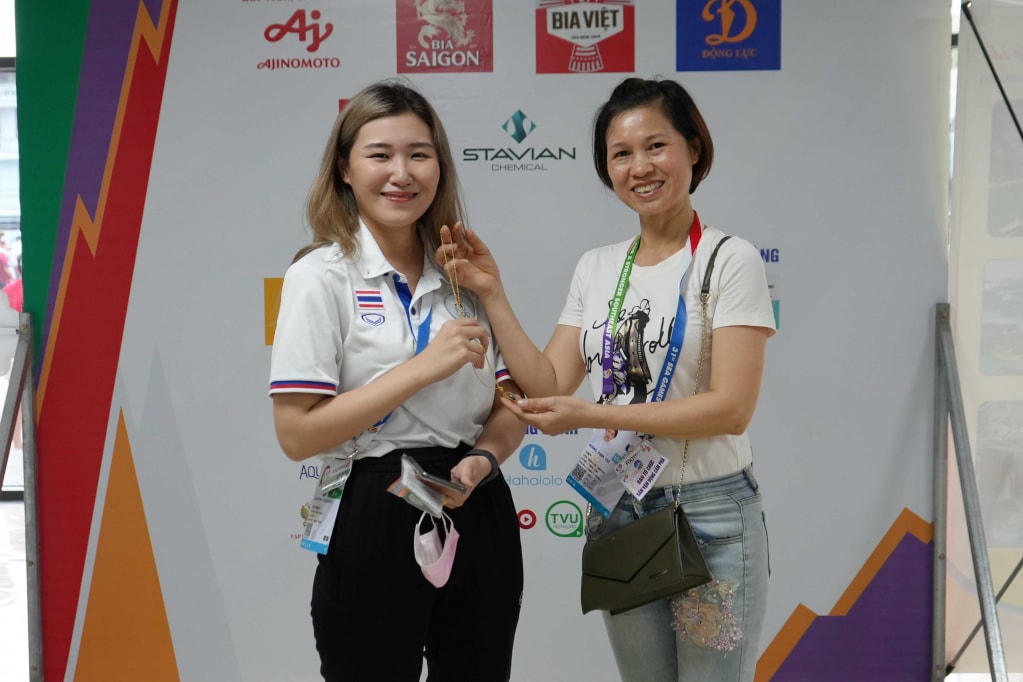 Chị Phạm Thị Hường, nhân viên phục vụ của Trung tâm Truyền thông và Văn hóa Cẩm Phả, trao trả lại sợi dây chuyền vàng bị đánh rơi cho thành viên đội bóng đá Thái Lan là chị Bam. Ảnh: Trung tâm TT&VH Cẩm Phả.