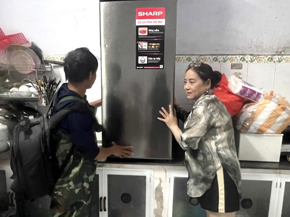 Người dân di chuyển tủ lạnh, ti vi lên cao tránh ngập nước.