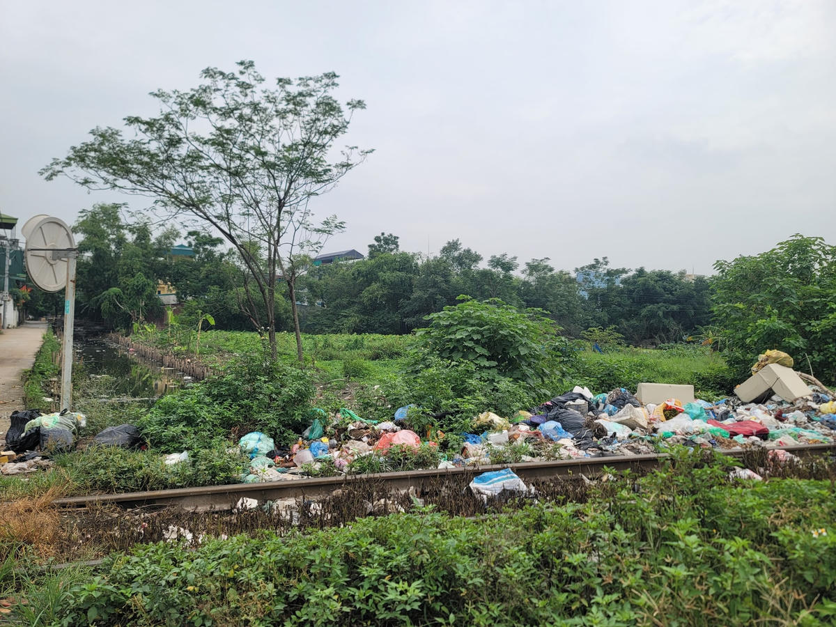 Rác ngập tràn từ trên bờ đê xuống mặt sông.