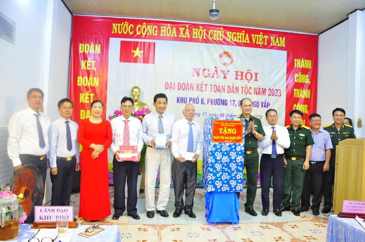 Trung tướng Nguyễn Văn Nam và ông Phạm Minh Tuấn trao quà cho đại diện khu phố.