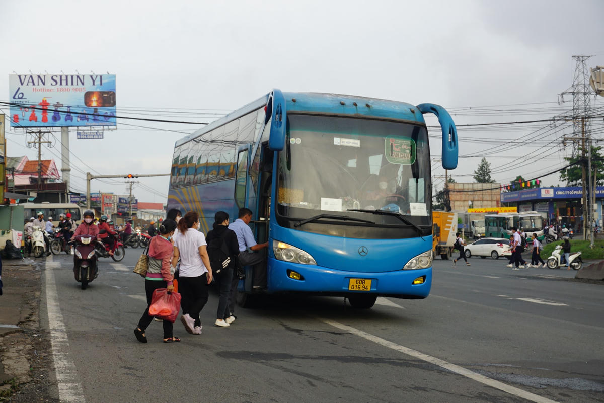 Một chiếc xe đưa đón công nhân vượt đèn đỏ, đón khách ngay giao lộ Quốc lộ 51 – đường Ngô Quyền (phường An Hòa). Ảnh: Mạnh Thìn.