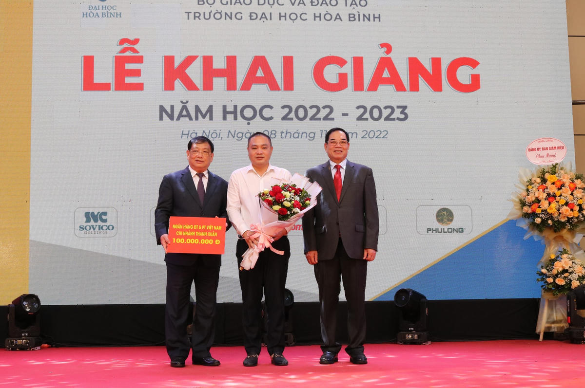 Lãnh đạo Trường Đại học Hòa Bình tặng hoa cho đại diện các đơn vị tài trợ học bổng cho sinh viên nhà trường.