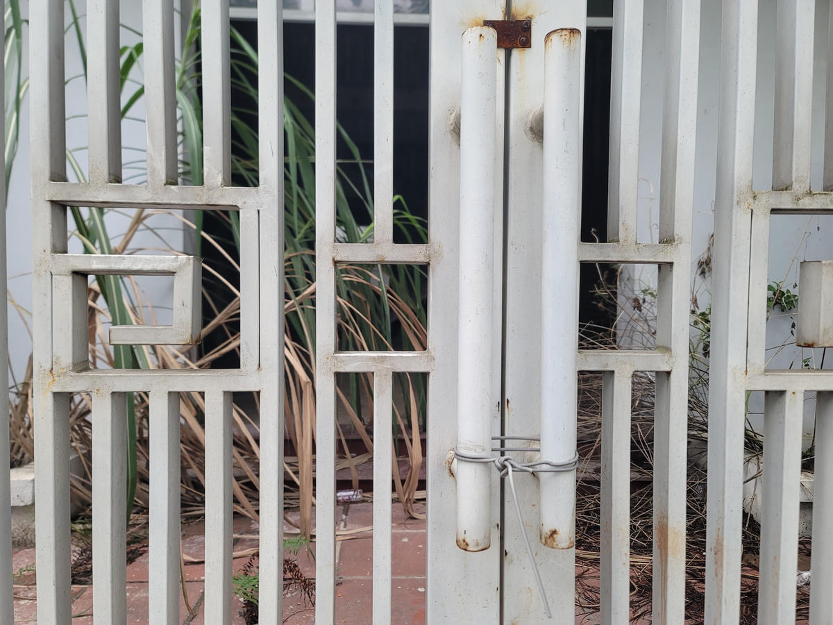 Cửa cổng được buộc bằng dây thép cố định từ lâu.