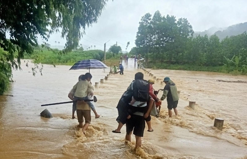 Lực lượng chức năng cõng người dân đi qua đường tràn xã Xuân Khang (huyện Như Thanh).