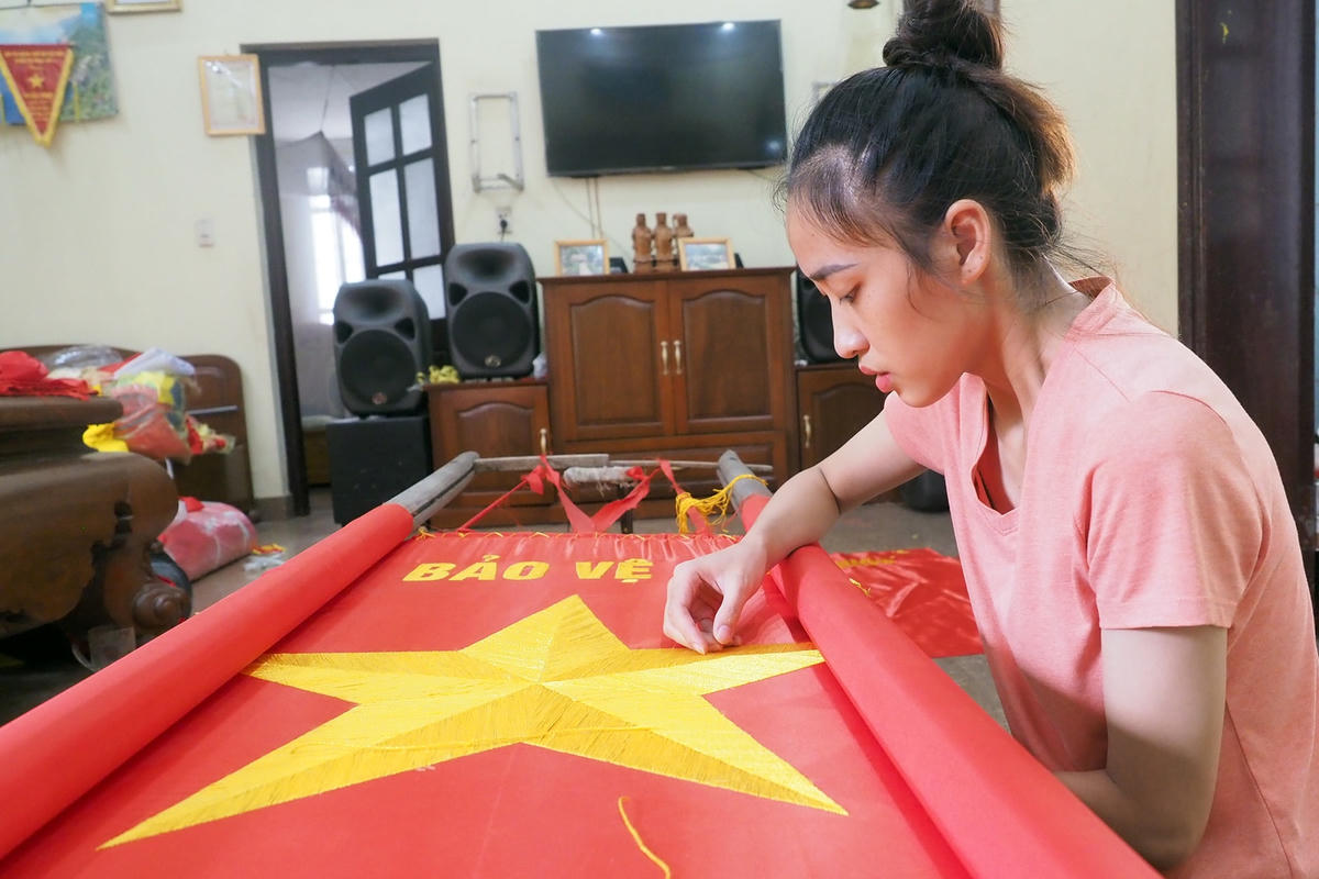 Chị Vân Anh với những đường kim, mũi chỉ cho ngôi sao năm cánh trên nền cờ đỏ.