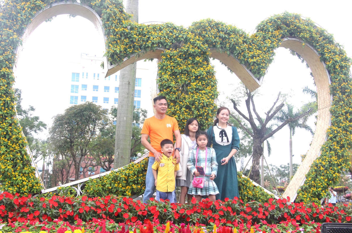Một gia đình tạo dáng bên tiểu cảnh hình trái tim.