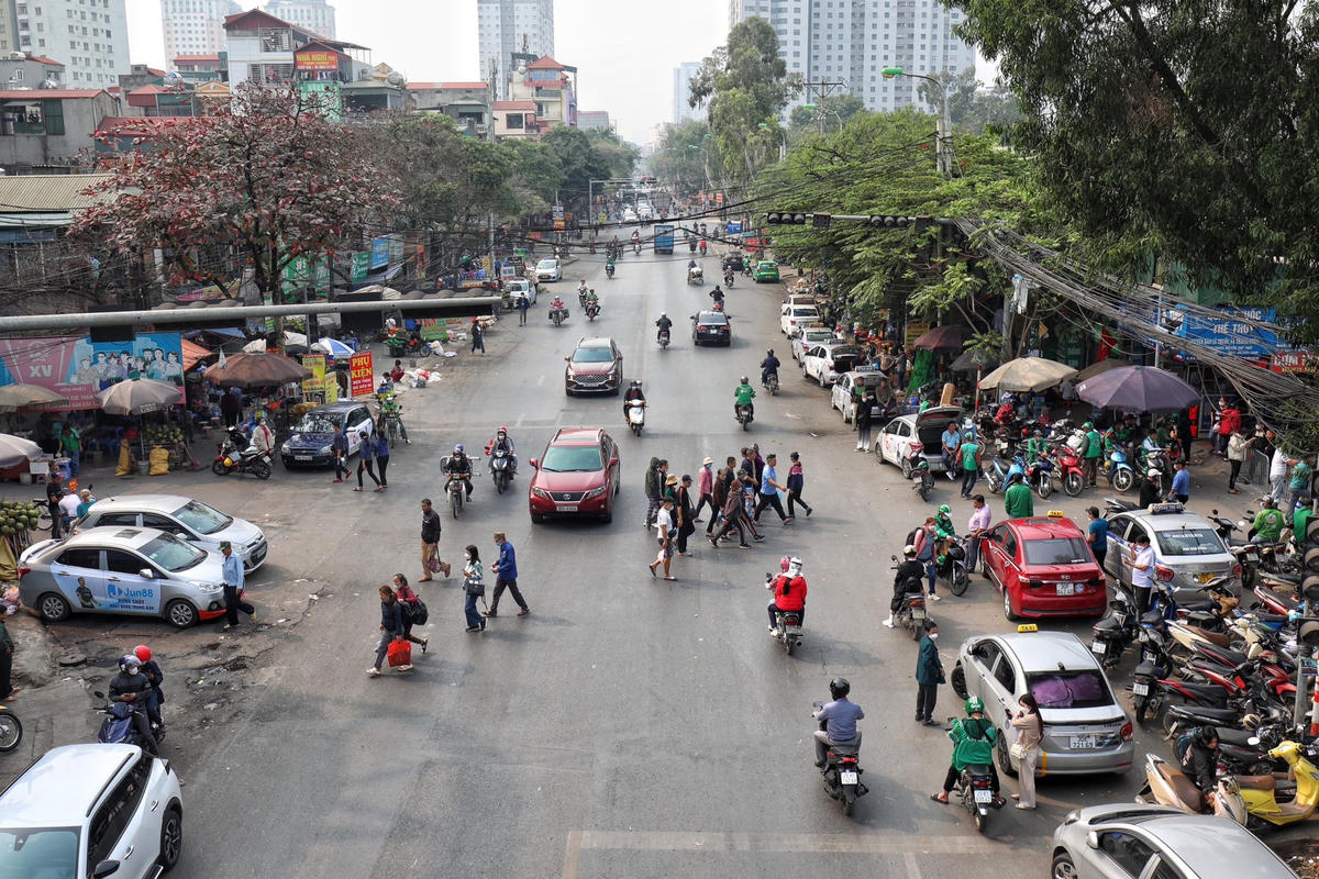 Hình ảnh người đi bộ ngược, xuôi ngay dưới chân cầu vượt bộ hành.