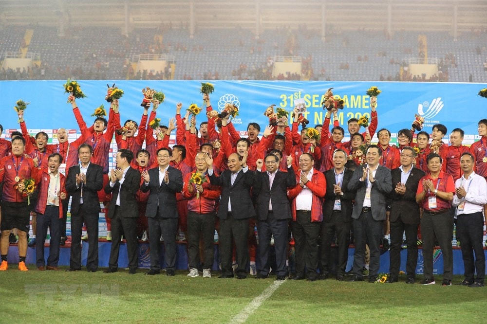 Chủ tịch nước Nguyễn Xuân Phúc, Thủ tướng Phạm Minh Chính, Chủ tịch Quốc hội Vương Đình Huệ, Thường trực Ban Bí thư Võ Văn Thưởng và các đại biểu chụp ảnh chung với Đội tuyển bóng đá U23 Việt Nam vừa giành Huy chương Vàng môn bóng đá nam SEA Games 31. Ảnh: TTXVN.