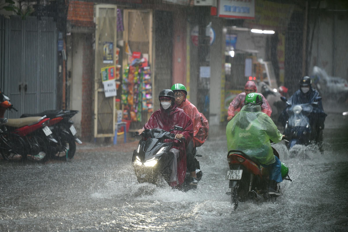 Nước ngập ngang bánh xe máy khiến người dân đi lại khó khăn...