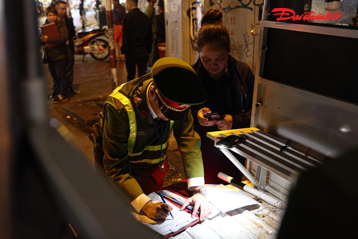 Lực lượng chức năng lập biên bản vi phạm hành chính đối với các hàng quán lấn chiếm vỉa hè.