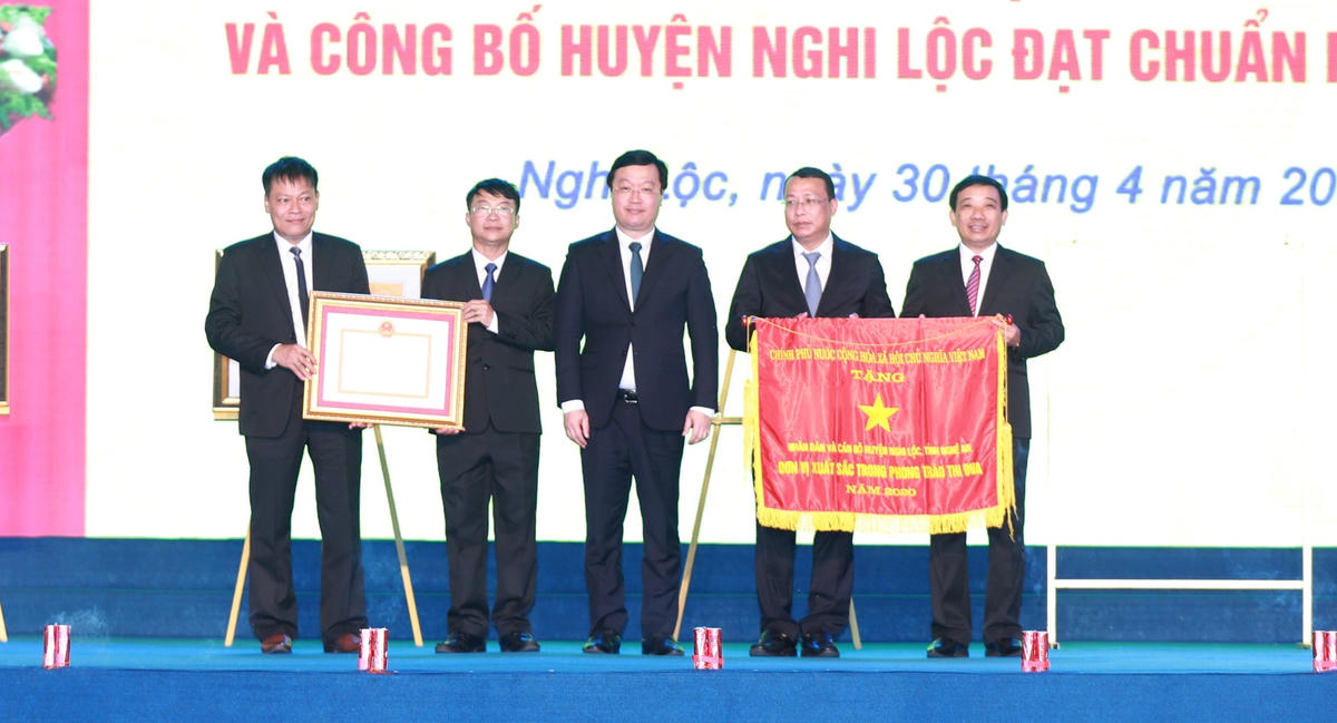 Ông Nguyễn Đức Trung, Phó Bí thư Tỉnh ủy, Chủ tịch UBND tỉnh Nghệ An trao Bằng công nhận huyện Nghi Lộc đạt chuẩn Quốc gia về xây dựng nông thôn mới và trao Cờ Thi đua của Chính phủ.