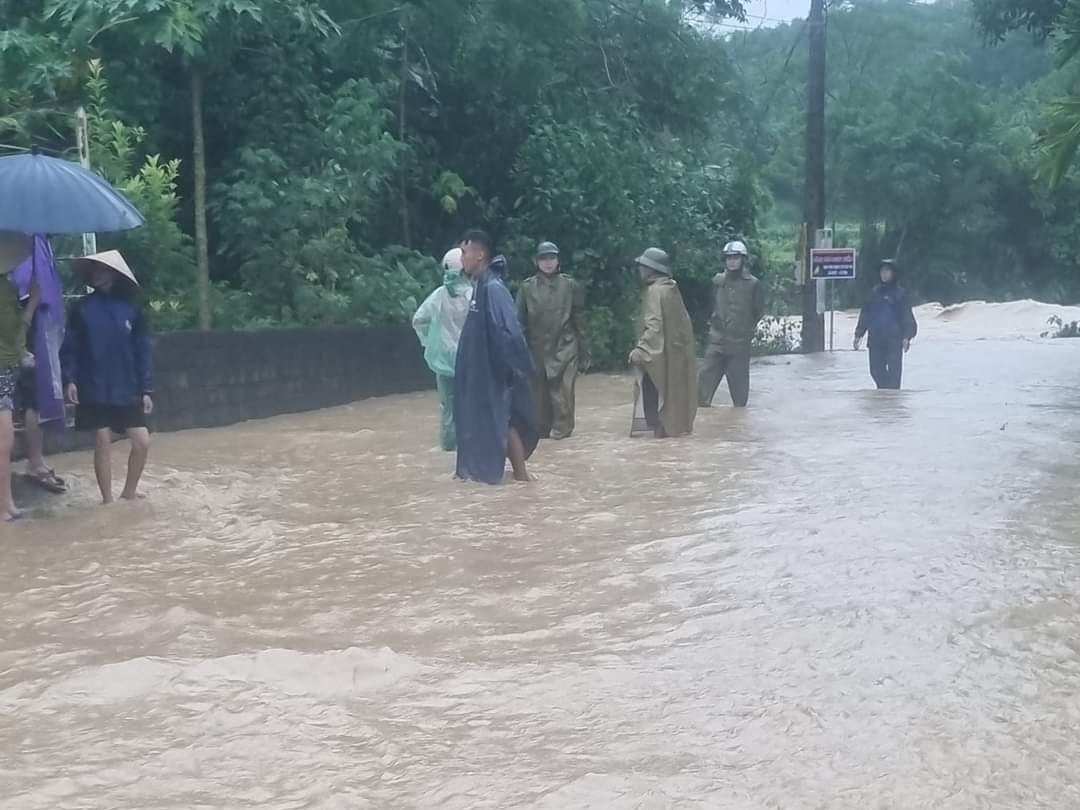Công an xã Vạn Xuân (huyện Thường Xuân) giúp đỡ người dân đi sơ tán khỏi vùng bị ngập lụt.