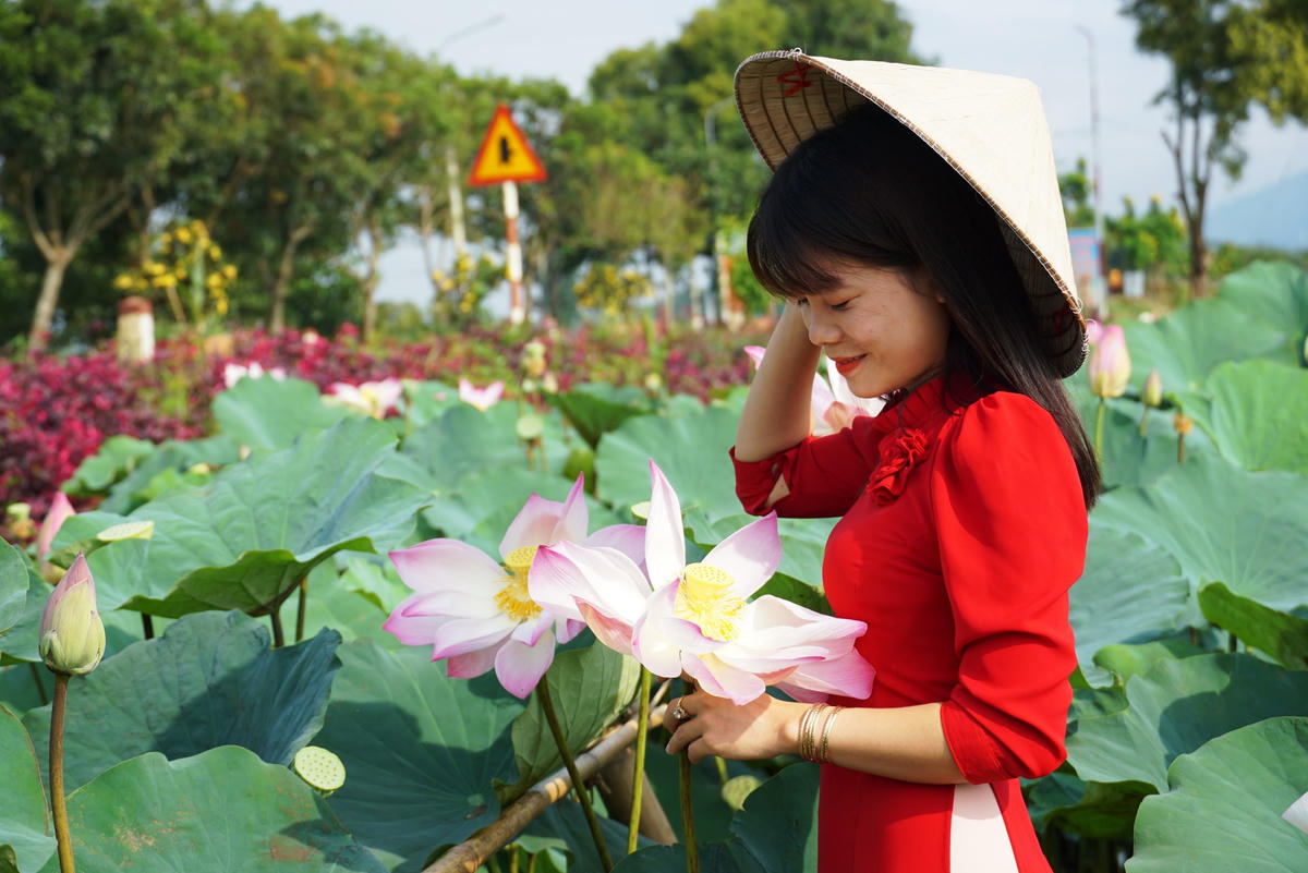 Chị Trần Thị Phương, Bí thư Đoàn xã Lang Minh áo dài thướt tha bên “Quốc hoa”. Ảnh: Mạnh Thìn.