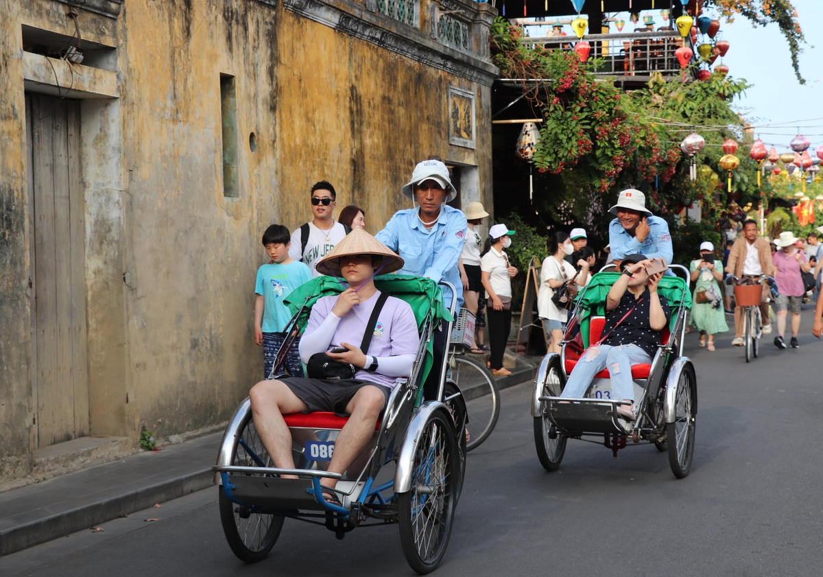 Du khách ngồi xích lô đi dạo trên đường Bạch Đằng.