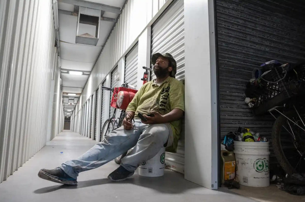 Spell dỡ đồ đạc vào thùng chứa của ông khi nhiệt độ chạm mức 44 độ C. Ảnh: The Guardian.