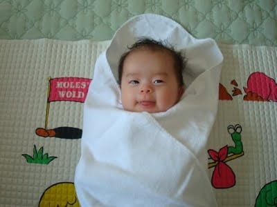 Đặt bé vào khăn bông to và lau khô người. Ảnh: Zingnews.