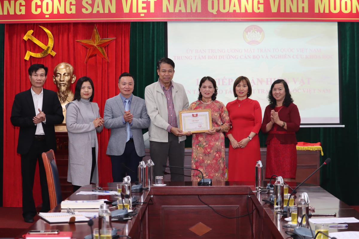Lãnh đạo Trung tâm Bồi dưỡng cán bộ và Nghiên cứu khoa học MTTQ Việt Nam trao tặng Giấy ghi nhận cho bà Nguyễn Thị Nhị.