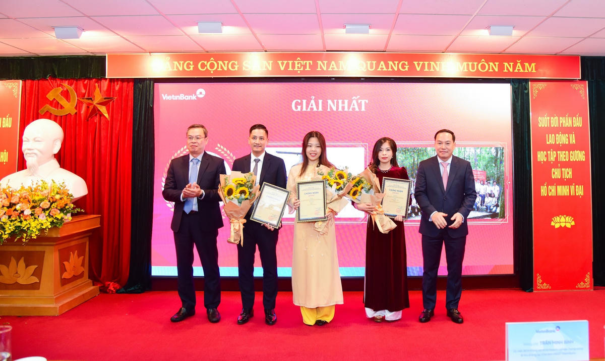 Ông Hồ Xuân Trường - Phó Bí thư Đảng ủy Khối DNTW  (bên phải) và ông Trần Minh Bình - Ủy viên Ban Chấp hành Đảng bộ Khối DNTW, Bí thư Đảng ủy, Chủ tịch Hội đồng quản trị NHCTVN (bên trái) trao Giấy chứng nhận và hoa cho các tác giả/nhóm tác giả đạt giải Nhất.