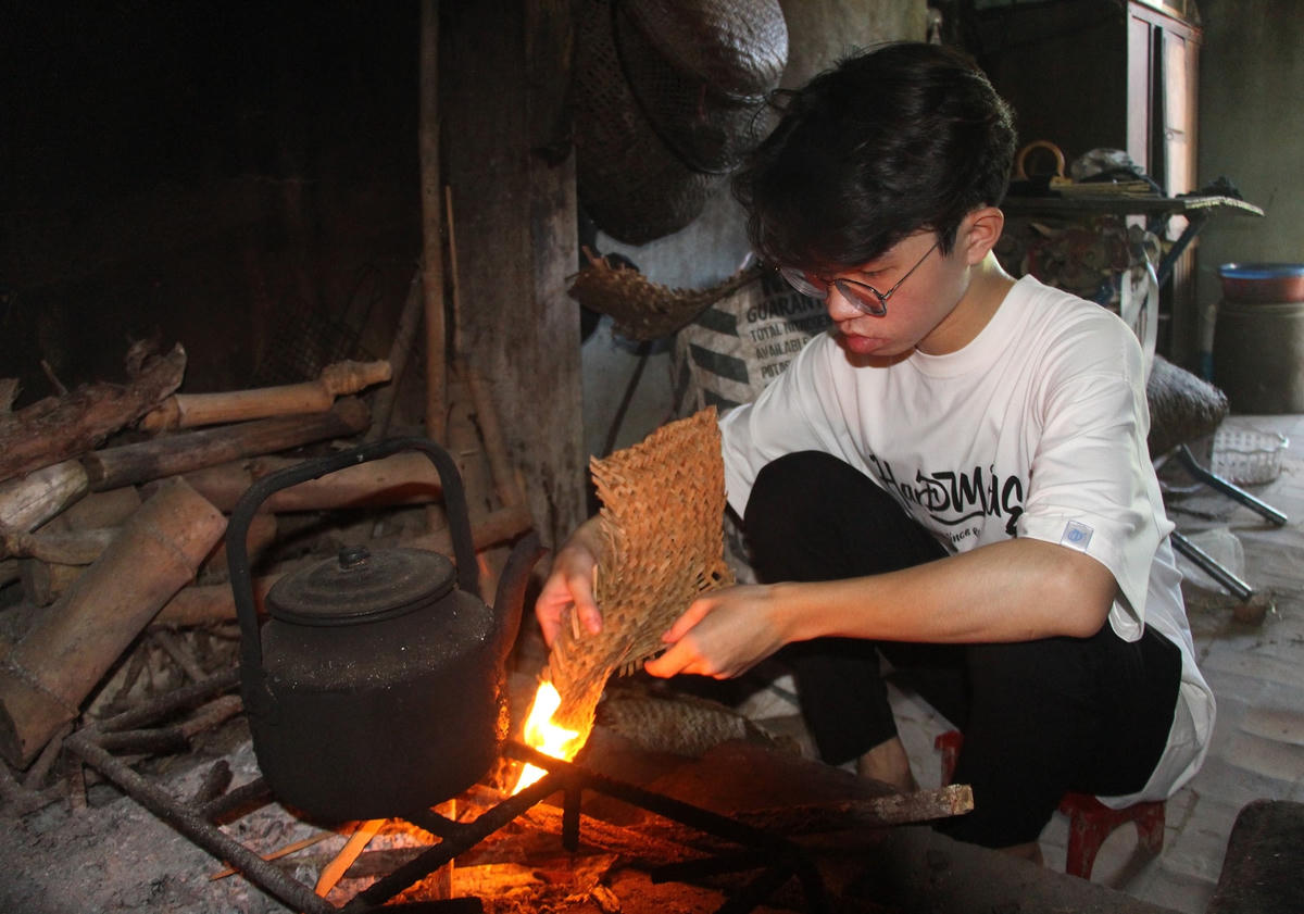 Em Công Hiếu phụ giúp mẹ nấu nước uống.