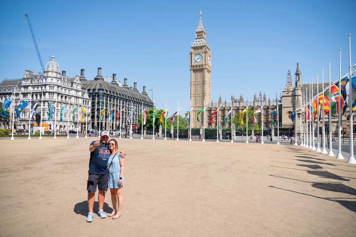 Khách du lịch tạo dáng selfie ở Quảng trường Quốc hội, trung tâm London dưới cái nắng 40 độ C. Ảnh: The Guardian.