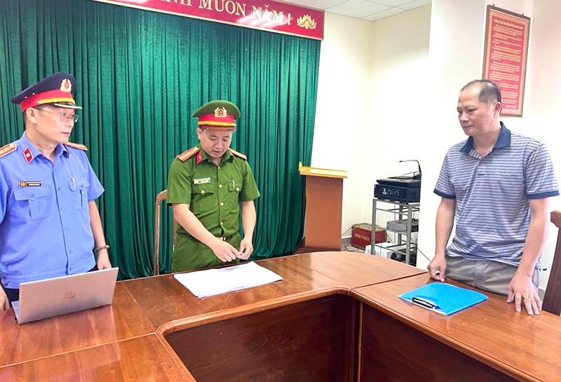 Lực lượng chức năng tống đạt quyết định khởi tố đối với bị can Nguyễn Thanh Long (ảnh: CAQB)