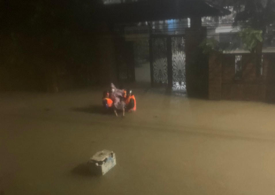Lực lượng chức năng đưa ông Tài đi cấp cứu trong đêm mưa lũ.