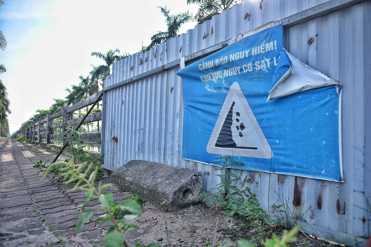 Các lan can đã gãy, đổ được gia cố bằng các tấm tôn kèm theo tờ cảnh báo nguy hiểm khu vực có nguy cơ sạt lở.
