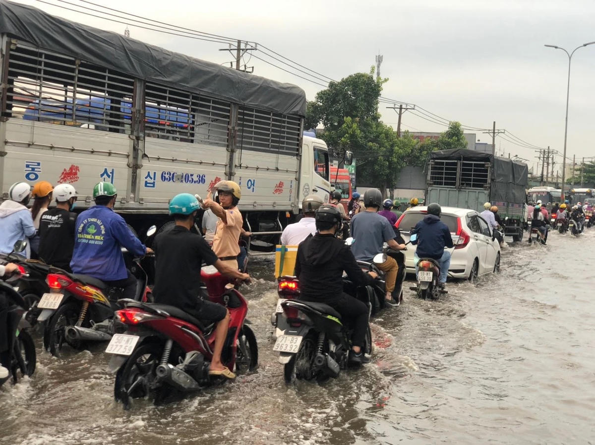 Triều cường dâng cao “tấn công” đoạn Quốc lộ 1 qua thị trấn Tân Túc, huyện Bình Chánh, TP HCM. Ảnh: PC08.