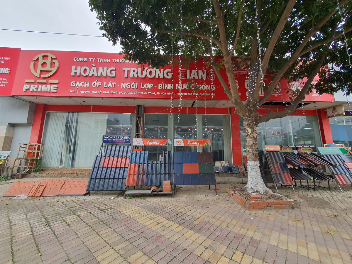 Siêu thị Hoàng Trường Giang có 2 mặt tiền, một mặt ở đường Hữu Nghị, một mặt ở đường Lê Thánh Tông, bày bán ngói lợp tràn ra vỉa hè.