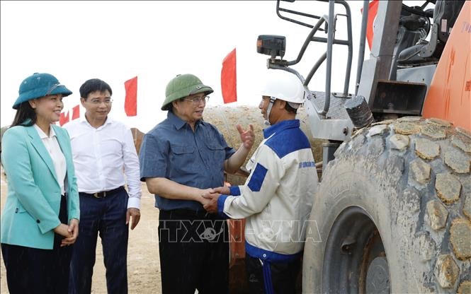 Thủ tướng Phạm Minh Chính động viên công nhân đang thi công tuyến đường Đông - Tây đoạn qua tỉnh Ninh Bình. Ảnh: Dương Giang/TTXVN.