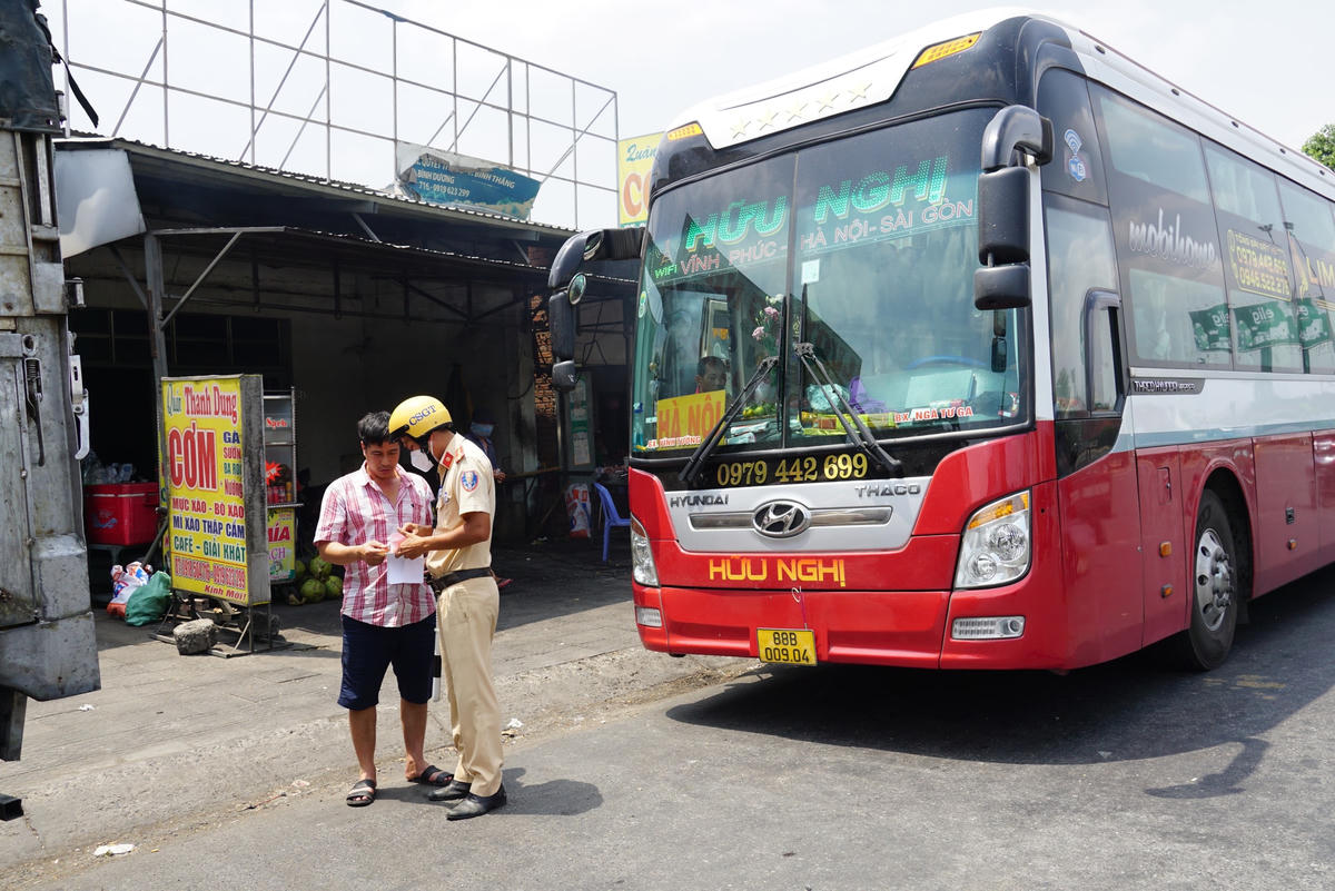 Lực lượng CSGT  kiểm tra giấy tờ của lái xe khách vi phạm cấm dừng, cấm đỗ tại nơi có biển cấm. Ảnh: Mạnh Thìn.
