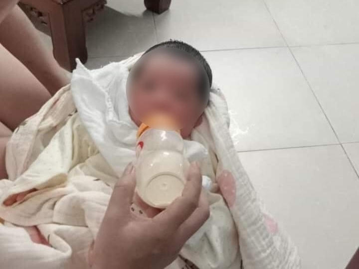 Bé gái sơ sinh được người dân cho bú sữa bình.