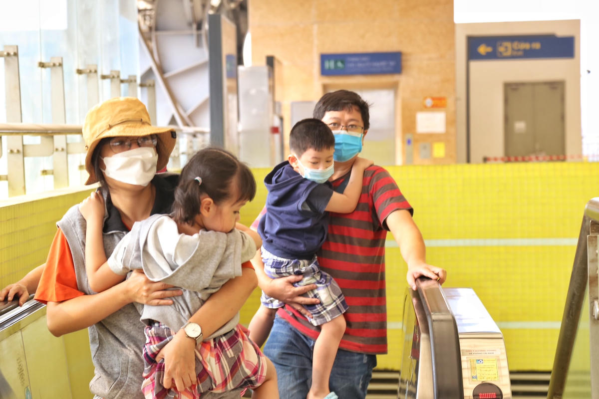 Hình ảnh những em nhỏ được bố mẹ cho đi chơi bằng tàu điện.