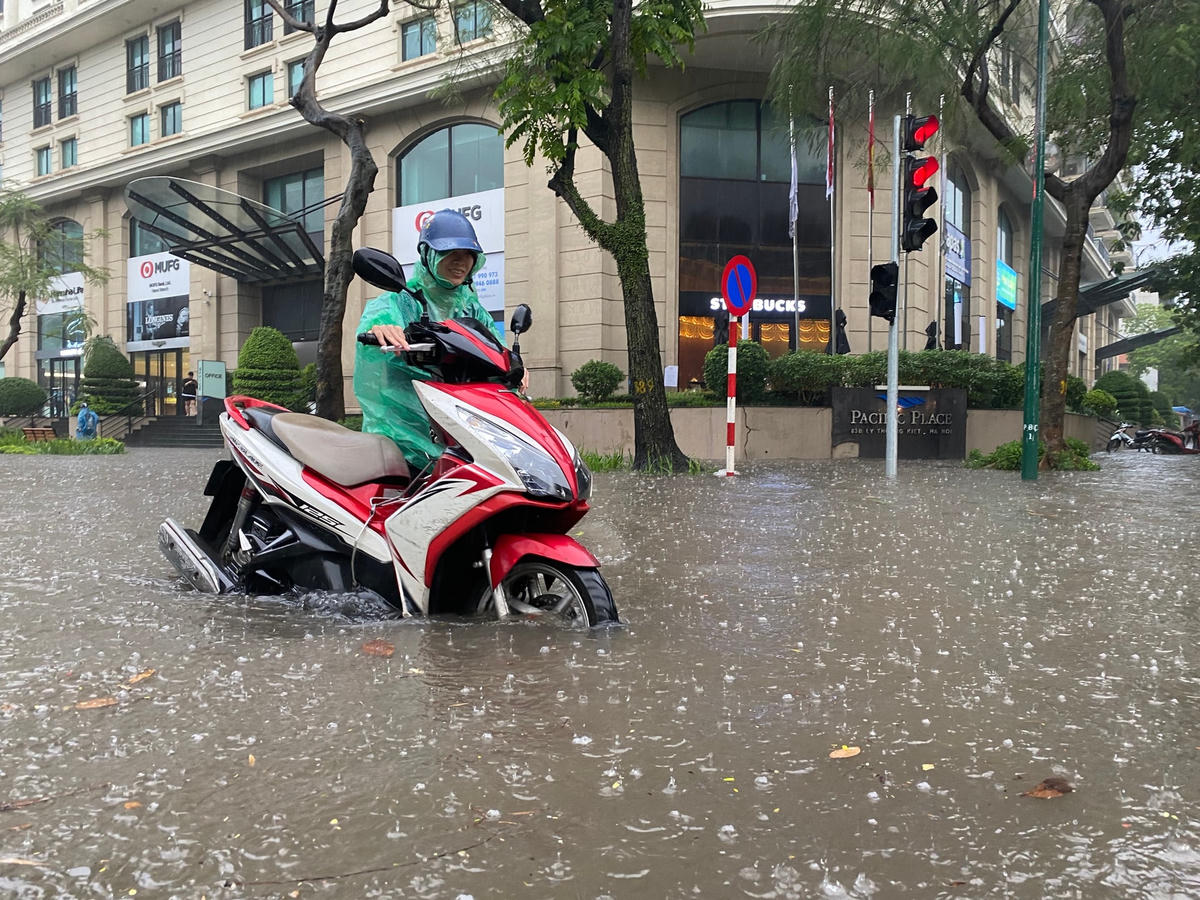 Nhiều người dân phải dắt xe do nước ngập quá bánh xe.