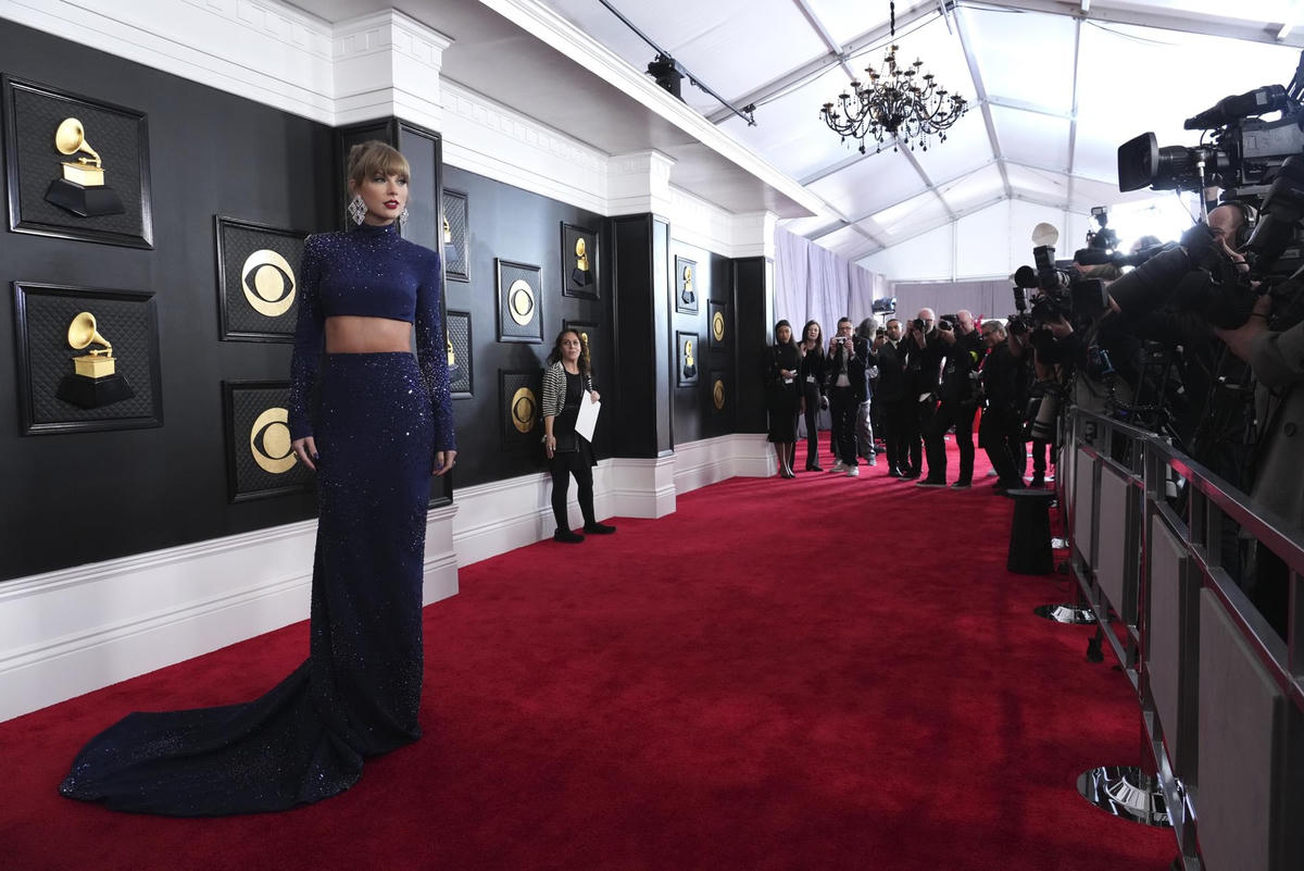 Taylor Swift, thể hiện kỷ nguyên Midnights, mặc một chiếc váy dài hai mảnh lấp lánh với áo crop top dài tay, cổ cao, tất cả đều từ bàn tay của Roberto Cavalli. Chúng có màu xanh nửa đêm. Cô mang thêm đôi bông tai kim cương nổi bật của Lorraine Schwartz, mái tóc búi cao. Ảnh: AP.