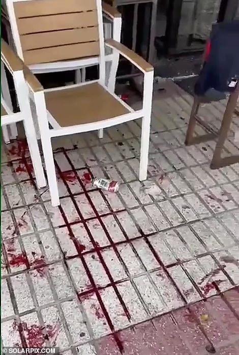 Máu vương vãi trên hè phố khi nhiều CĐV bị thương trong vụ việc.