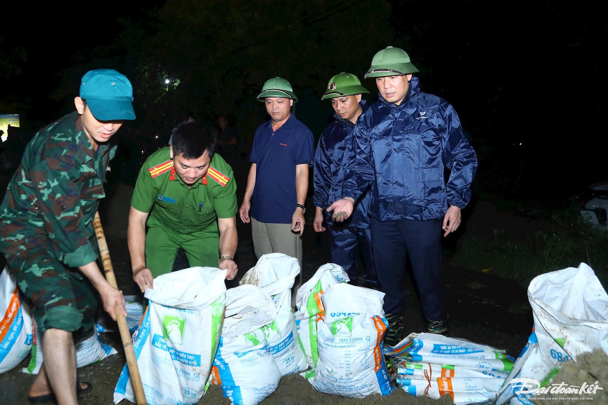 Ông Nguyễn Anh Đức, Chủ tịch UBND xã Xuân Mai (phía bên phải đội mũ cối) yêu cầu các lực lượng chức năng dùng bao tải cát để đắp các đoạn đê xung yếu, có nguy cơ ngập. 