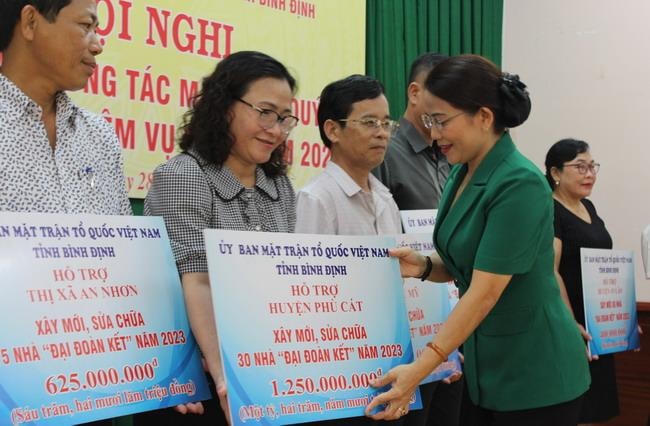 Bà Nguyễn Thị Phong Vũ, Chủ tịch Ủy ban MTTQ Việt Nam tỉnh Bình Định, trao bảng tượng trưng hỗ trợ ủy ban MTTQ Việt Nam các huyện, thị xã xây, sửa nhà đại đoàn kết. 