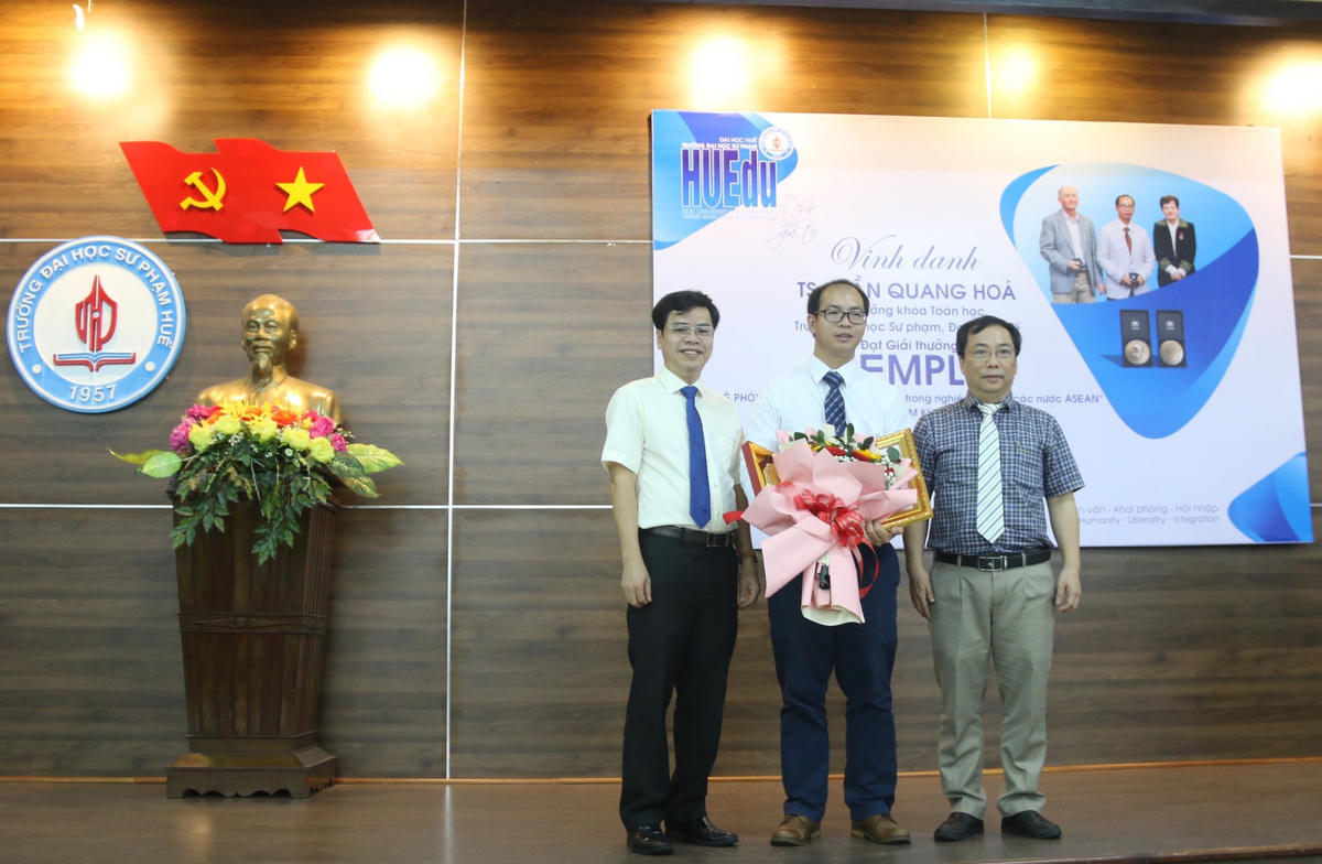 PGS.TS Nguyễn Thành Nhân (bìa trái), Phó Hiệu trưởng phụ trách Trường Đại học Sư phạm, Đại học Huế tặng hoa chúc mừng TS Trần Quang Hoá.