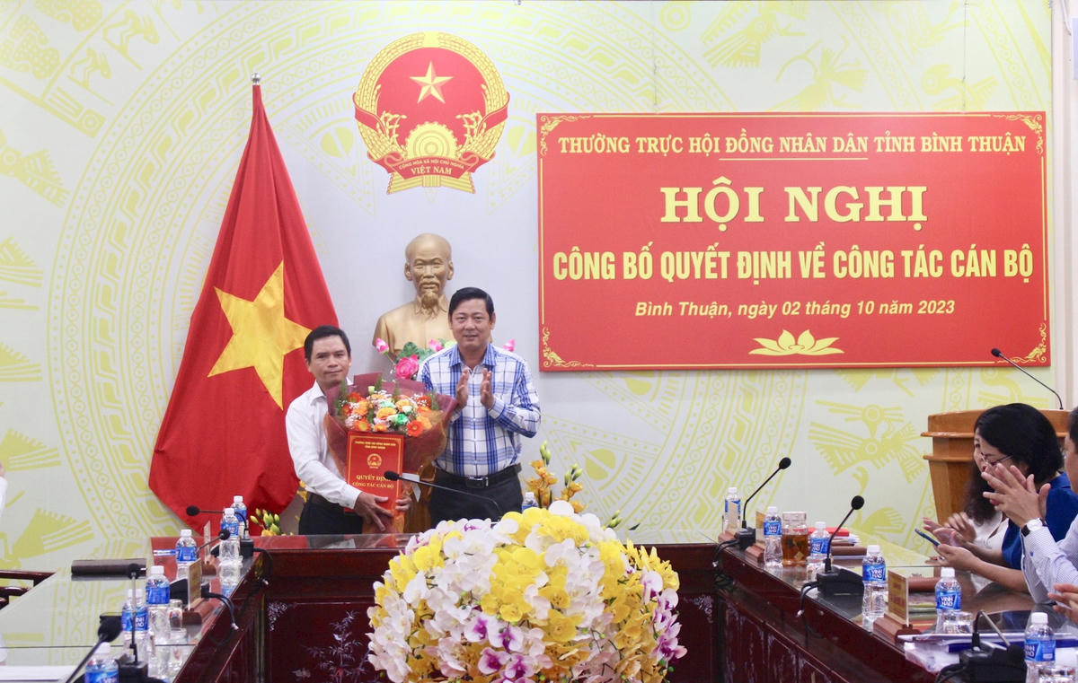 Ông Tiêu Hồng Phúc, Phó Chủ tịch Thường trực HĐND tỉnh  Bình Thuận trao quyết định và tặng hoa chúc mừng Tân Chánh Văn phòng Đoàn ĐBQH và HĐND tỉnh Ngô Minh Hoà.