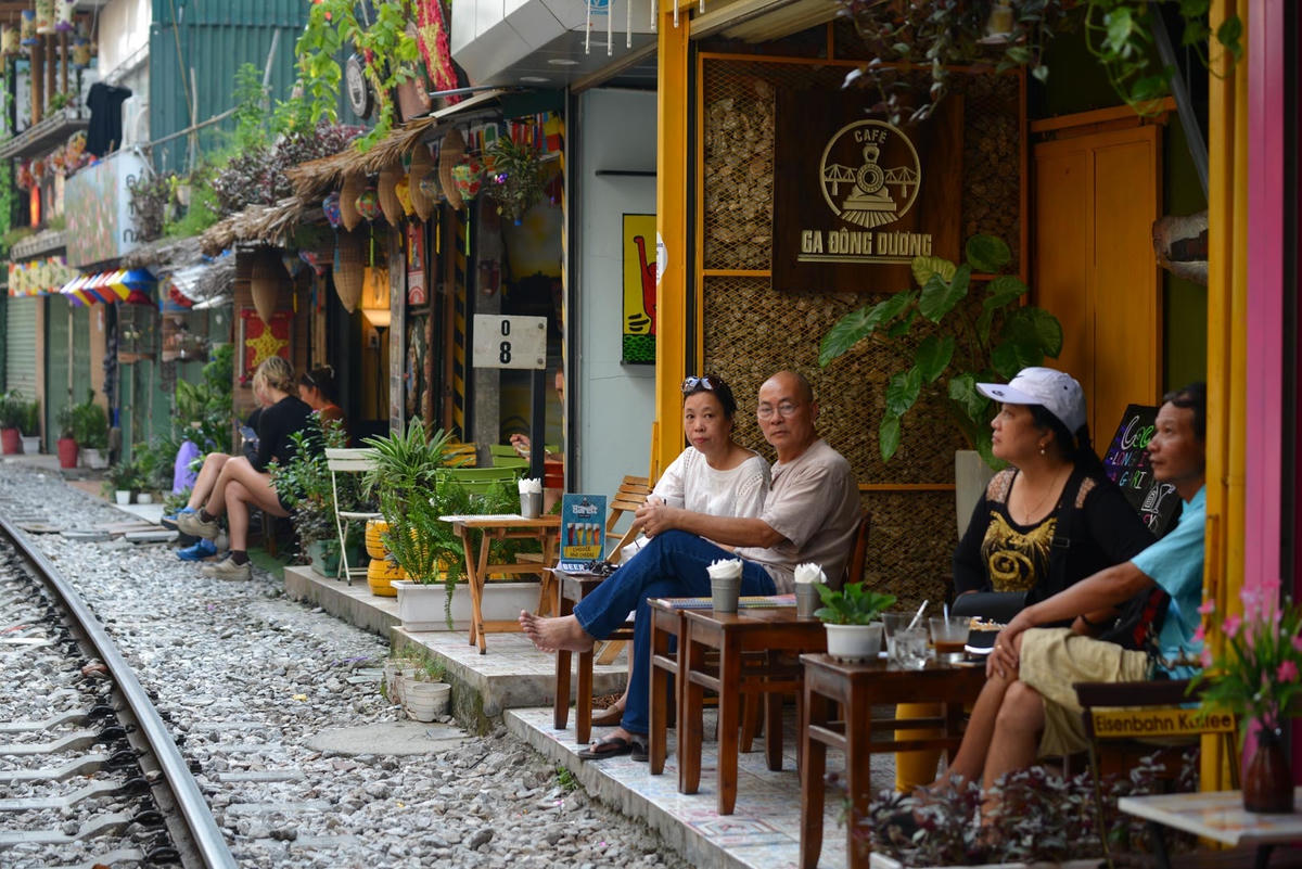 Nhiều người dân, khách du lịch cũng tranh thủ thưởng thức những cốc cà phê trước khi đến giờ phố đường tàu chính thức đóng cửa.