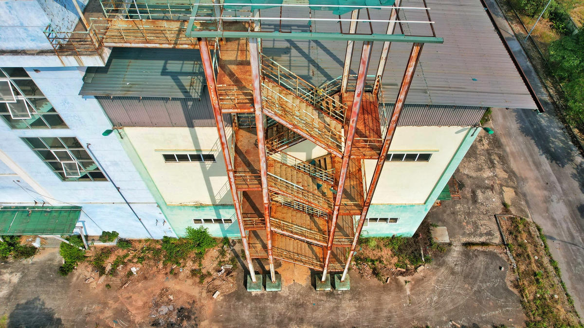 Cầu thang thoát hiểm bên ngoài nhà máy đã hoen rỉ.