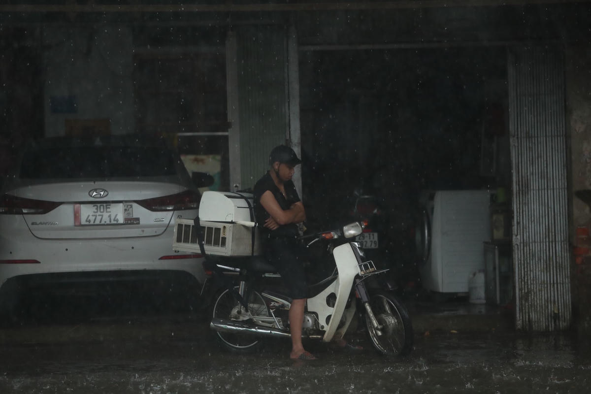 Một số người phải trú tại các hiên nhà dân để tránh mưa.